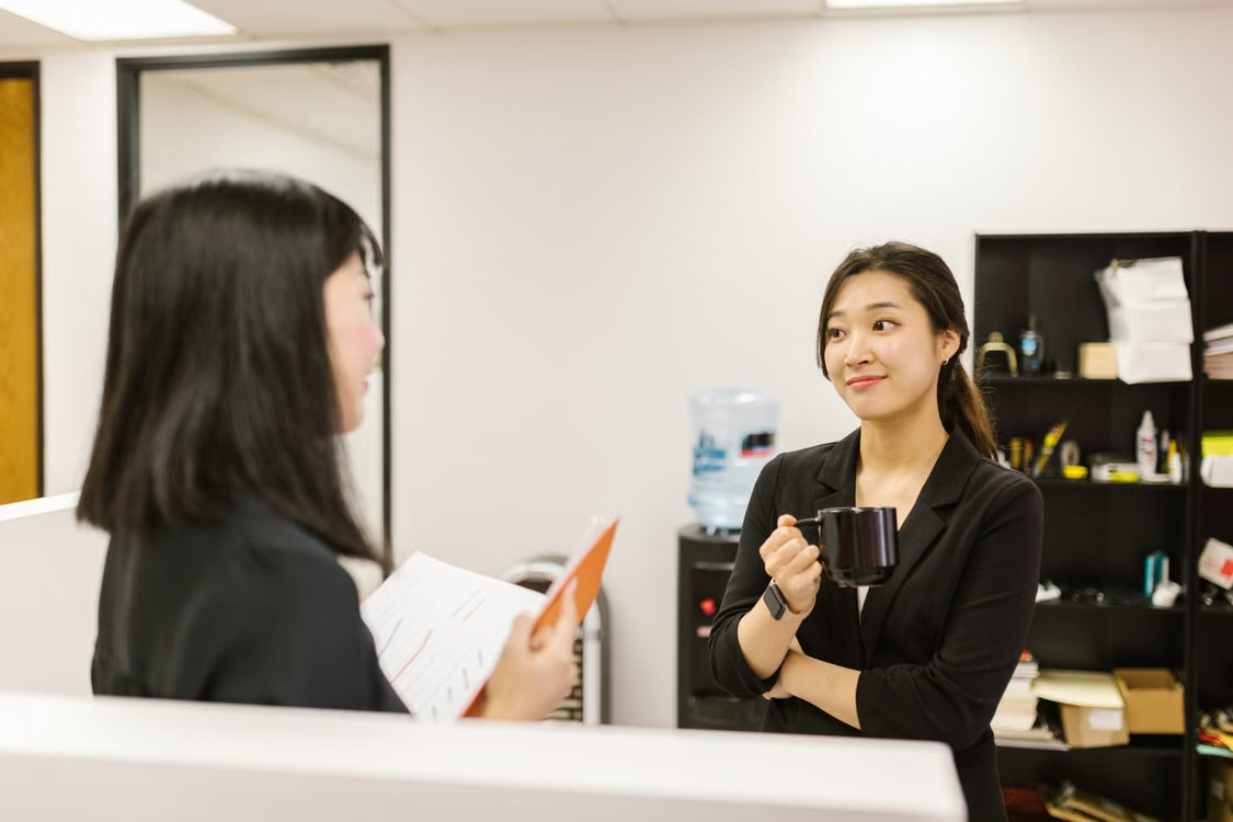 两位职场女性在办公室交流，体现 MBTI 在职业沟通与团队协作中的应用